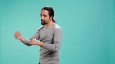 Kavga ediyormuş gibi yapan, yumruk atan, savunmayı elinde tutan bir adam. Dövüş sanatları ustası sahte boks yapıyor, dövüş duruşu yapıyor, egzersiz yapıyor, stüdyo arka planında izole edilmiş, kamera B