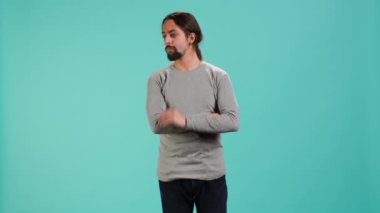 İnsan portresi parmaklarıyla boynu kaşıyor, tanıdık olmayan sesleri dinliyor, kaynağını bulmaya odaklanıyor. Başını eğen kişi, tanımlayıcı gürültüye odaklanıyor, stüdyo arka planı, kamera A