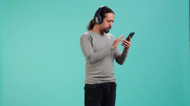 Rahat adam cep telefonundan, stüdyo arkaplanından müzik dinleyerek eğleniyor. Akıllı telefon cihazından çalan kaygısız kişi stüdyonun arka planında izole edilmiş melodileri duyuyor. Kamera A