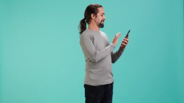 Akıllı telefon ekranında kayan adam, cep telefonunu sosyal medya bağlantılarını kontrol etmek için kullanıyor, stüdyo arkaplanı. İnternet sitelerini tarayan kişi, stüdyo arka planı, kamera A