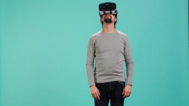 Sanal gerçeklik gözlüğü takan heyecanlı teknoloji hayranı etrafa bakıyor. Arap adam ileri teknoloji modern VR gözlükleri kullanıyor, dokunaklı hareketler yapıyor, stüdyo arka planı, kamera A