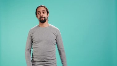 Satıcı parmağıyla işaret ediyor, tavsiye veriyor, izleyicilerle konuşuyor. Metin alanı gösteren, reklam yapan, stüdyo arka planında izole edilmiş bir adam, kamera B