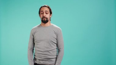 Adam omuz silkiyor, cevap veremiyor, ilgisiz bir yüz ifadesi var. Duygusuz insan el hareketi yapıyor, bilgisizliğini gösteriyor, stüdyo geçmişi, kamera B