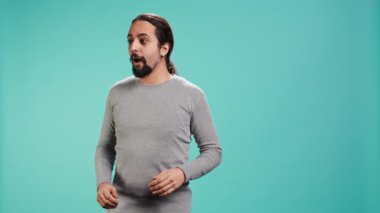 Etrafa huşu içinde bakan neşeli, geniş gözlü bir adamın portresi, güzel bir çevreye hayran, stüdyo arka planı. Heyecanlı meraklı insan etrafındaki manzaraya hayran, kamera B