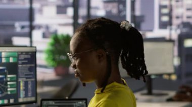 İşteki gülümseyen bilgisayar bilimcisinin PC kullanarak yazılım hata ayıklaması yapan portresi, kod satırlarındaki arızaları kontrol ediyor. Ofisteki neşeli bilişim uzmanı kodlama sorunlarını bilgisayar, kamera A kullanarak çözüyor.