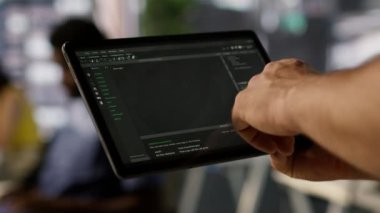 Veri bilimci, otomatikman karar verme süreçlerini analiz edebilen makine öğrenme modellerini kontrol etmek için tablet kullanır. Ofiste programlama yapmak için cihaz kullanan bilişim uzmanını kapat, Kamera A