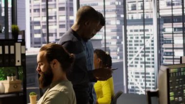 İşyerindeki bilgisayar bilimcileri tarafından yapılan yazılımın hata ayıklama çalışmalarını değerlendiren yöneticiler. Yönetim yöneticileri ellerinde tabletle ofiste dolaşırken, çalışanlar tarafından düzeltilmiş kodu kontrol ediyorlar, kamera A