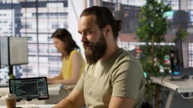 Çalışan PC monitörüne bakıyor, kahve içiyor, iş görüşleri bulmak ve projeyi bitirmek için gereken verileri kontrol ediyor. Bilgisayarda veri analiz eden, içecekten keyif alan adam, kamera A.