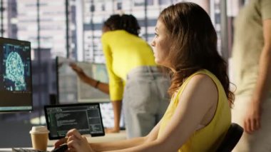 Yapay zeka makinesinin performans ve doğruluk modellerini optimize etmek için bilgisayar ve tablet üzerinde idari testler. Ofiste BT çalışanı karmaşık yapay zeka verilerini analiz ediyor ve yorumluyor, kamera A