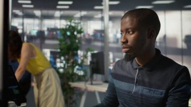 Sistem yöneticisi yazılım kalite güvencesi veriyor, tabletteki kaynak kodunu kontrol ediyor. Afrika kökenli bir Amerikan bilişim uzmanının cihaz üzerindeki kodları incelemesi, hataları düzeltmesi, kamera B