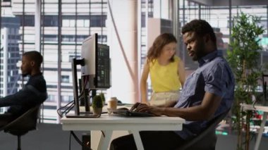 Afrika kökenli Amerikalı bir adam çeşitli programlama dilleri kullanarak yazılım uygulamaları tasarlıyor, geliştiriyor ve sürdürüyor. Sistem yöneticisi şirket sunucularını hata ayıklıyor, hataları önlüyor, kamera A