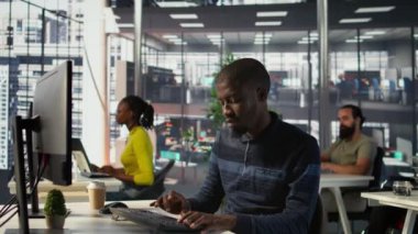 Programcı yazılım hata ayıklama yapıyor, tekerlekli sandalyedeki gülümseyen takım liderinden yardım istiyor. Çalışan kodlama hatalarını düzeltir, engelli neşeli yönetici tarafından yardımcı olunur, kamera B