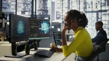 Ofisteki çalışanlar mesai sırasında esniyorlar. Bilgisayardaki yapay zeka yazılımına bakarken yorgun hissediyorlar. Yorgun afrikalı amerikan yapay zeka şirketi çalışanı çalışma alanında uykulu, kamera B