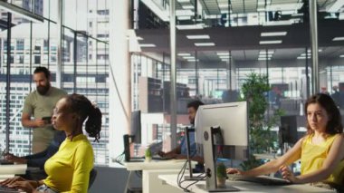 İş vardiyası sırasında ofis masasında oturan bir işçi, online mali iş belgelerine bakıyor. Çalışma alanındaki şirket çalışanı PC ile ilgili görevler yapıyor, üretken olmak, kamera B