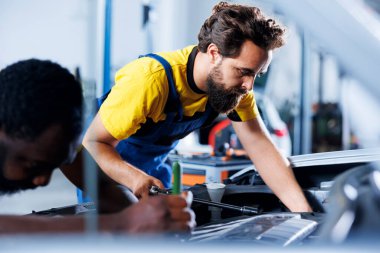 Araba servisindeki meslektaşlar direksiyon mekanizmasını değiştirdikten sonra cıvataları sıkmak için tork anahtarı kullanırlar. Takım çalışması otomobil tamircisi çalışanları müşteri otomobillerini tamir etmek için profesyonel araçlar kullanıyorlar