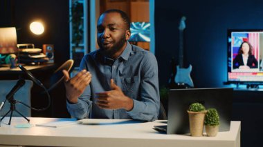 Gülümseyen içerik yaratıcısı profesyonel kayıt cihazlarını kullanarak çevrimiçi yayın platformları için kanal girişini filme alıyor. BIPOC etkileyicisi hayran kitlesini karşıladı, bugün video konusunu sunuyor