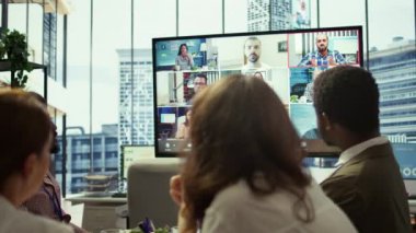 Genel müdür toplantı odasında, personeliyle güncellemeleri tartışmak üzere çevrimiçi bir video konferans görüşmesine başlıyor. İş ortakları büyüme için finansal planlamayı gözden geçiriyorlar. Kamera B.