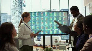 Çeşitli iş arkadaşları, yenilikçi fikirler üretmek, pazar verilerini analiz etmek ve iş performansını artırmak için stratejik planlar geliştirmek üzere bir toplantı odasında toplandılar. Atılgan brifing toplantısı. Kamera B.