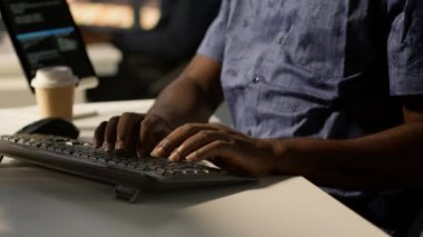 Veri girişi yapan, klavyede yazan, görevleri çözen bir adam. Çalışma alanındaki ofis görevlisinin kapanışı. Belgelerin kalite güvencesi beklentilerine ve standartlarına uygun olduğundan emin olun. Kamera A: