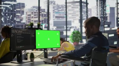 Engellilik testi yapan, programları ve sistemleri yeşil ekran PC 'ye yerleştiren kişi. Tekerlekli sandalyedeki yazılım teknisyeni. Model bilgisayardaki kodu kontrol ediyor. Ofiste oturuyor.