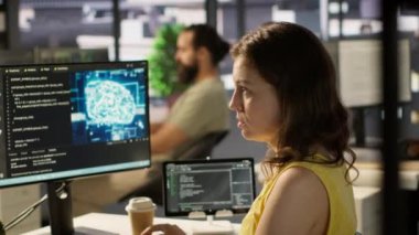 İşteki sistem yöneticisi PC kullanarak AI yazılımının hata ayıklamasını yapıyor, kod satırlarındaki arızaları kontrol ediyor. Bilgisayar, kamera A kullanarak yapay zeka kodlama sorunlarını çözmede bilişim uzmanı.