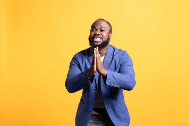 Dost canlısı Afrikalı Amerikalı adam özür dilemek için el ele tutuşup af diliyor. Özür dileyen BIPOC 'lu adam özür diliyor, özür diliyor, stüdyo geçmişinden izole edilmiş.