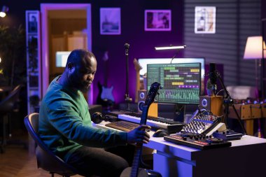 Müzik yapımcısı akustik enstrüman ile müzik yapmaya hazırlanıyor, kendi stüdyosunda bir film müziği kaydetmek için çalışıyor. Ses düzenleyicisi gitar müziği kaydediyor, karıştırma konsolu ile düzenliyor.