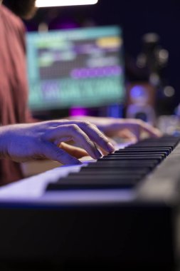 Elektronik piyano klavyesine notalar çalan ses mühendisi, karıştırma ve ustalaşma oturumları için kendi melodilerini yaratıyor. Müzisyen sanatçı şarkı bestelemek için midi denetçisini oynuyor. Kapat..