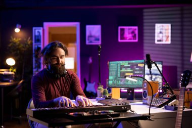 Yeni bir soundtrack kaydetmek için piyano çalan modern sanatçı, Midi kontrolör elektronik klavye kullanarak bir şarkı bestelemeye çalışıyor. Şarkıcı besteci şarkı yaratmak için enstrüman tuşları çalıyor.