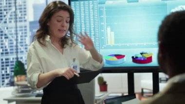 İş arkadaşları bir şirkette problem çözme toplantısına katılıyorlar, verileri görselleştirmek ve karmaşık iş sorunları için çözümler geliştirmek için etkileşimli bir kurul kullanıyorlar. Analiz sunumu. Kamera A.