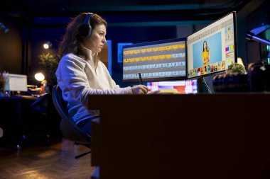 Işık ve renk dengesini düzenlemek için grafik tablet kullanarak müzik dinleyen foto editörü, dergiler için fotoğraf dağıtıyor. Resimleri düzenlemek için aygıt üzerinde stil kullanan kulaklıklı grafik tasarımcısı