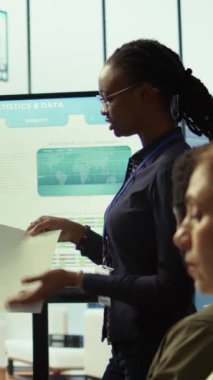 Üst düzey bir yönetim kurulu odasında çalışanlar beyin fırtınası yapmak ve stratejiler oluşturmak, istatistikleri analiz etmek, iş gelişimini hızlandırmak ve başarılı bir proje sağlamak için toplanıyorlar. Atılgan