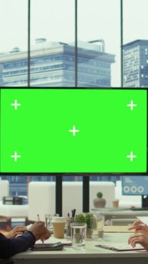 Dikey Görüntü Çeşitliliği çalışma ekibi, pazar eğilimlerini incelemek üzere üst düzey yönetim kurulunda toplanan büyük yeşil ekran ile kurumsal stratejileri tartışıyor. Ticari büyüme ve genişleme için yeni fikirleri paylaşmak