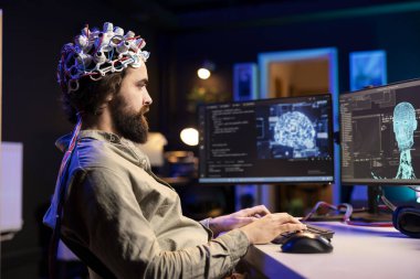 Software engineer specializing in AI using EEG headset to upload consciousness into computer. IT expert using high tech gear to create connection between brain and PC clipart