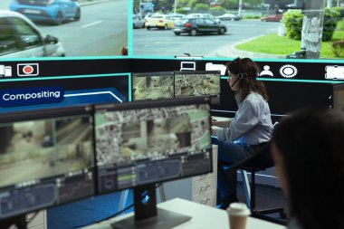 Kontrol merkezi operatörü, şehir trafiğinde düzensizlikleri bulmak için güvenlik kamerası görüntülerini izliyor, büyük ekran. Çalışan, CCTV radar güvenlik sistemi üzerinden veri topluyor.