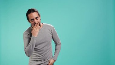 Neşeli oyuncu adam kameraya öpücük yolluyor, flört ediyor. Havadan öpücükler yollamak, romantik jestler yapmak, stüdyo arka planında izole olmak, kamera B