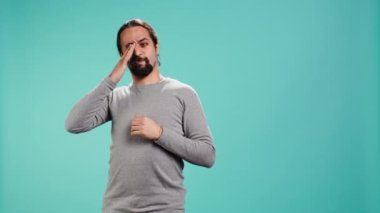 Aşırı çalışmaktan ve uykusuzluktan yorgun hisseden, gözlerini ovuşturan, esneyen, stüdyo arka planında soyutlanmış bir adam. Yorgun insan kendini uykulu, yorgun hissediyor, stüdyo arkaplanı, kamera B
