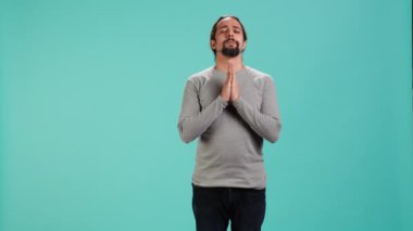 Dindar bir adam Tanrı 'sına dua ediyor, af diliyor. İbadet eden, el kol hareketi yapan, itiraf eden, af dileyen, stüdyo arka planında izole edilmiş, kamera A