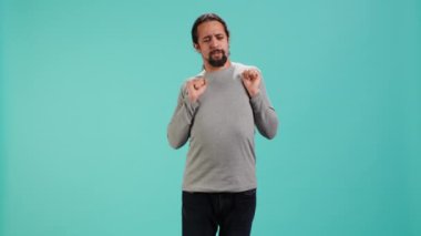 Vücudunu geren bir adamın portresi, kaslarda yorgunluk ve gerilim hisseder. Bacakları burkulmuş yorgun bir insan stresi azaltmak için uzuvlarını esnetiyor, stüdyo arka planı, kamera A