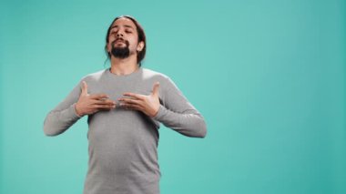 Rahatlamak, pozitif enerji kazanmak ve stresi ortadan kaldırmak için nefes alıp veren insan portresi. Stüdyonun arka planında izole edilmiş solunum egzersizleri yapan kişi, kamera B