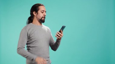 Olumlu duyguları olan neşeli bir adam telefon görüşmesinde arkadaşlarıyla konuşmaktan zevk alıyor. Akıllı telefon, stüdyo geçmişi. Yüzünde gülümseme olan mutlu insan, telefon görüşmesi sırasında iyi haberler alıyor, kamera B