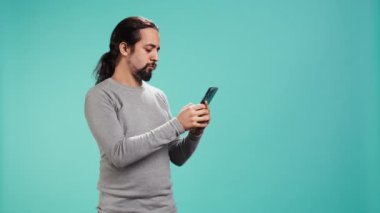 Telekonferans toplantısında arkadaşlarıyla dostça sohbet eden gülümseyen adam akıllı telefon, stüdyo geçmişi kullanıyor. Çevrimiçi video görüşmesi sırasında arkadaşlarla takılırken eğlenen kişi, kamera B