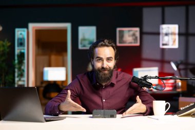 Yeni başlatılan taşınabilir V monte bataryasının video incelemesini yapan neşeli teknoloji uzmanı. Gülümseyen çevrimiçi yıldız, izleyiciler için lityum li-ion şarj cihazının kutusunu açıyor