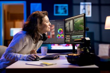 Gülümseyen video düzenleyici, özel program kullanarak video montaj yaparken kullanılacak anahtar çerçeveleri seçiyor. Ofisteki film projesini kesmek için bilgisayardaki düzenleme araçlarını kullanan mutlu videograf