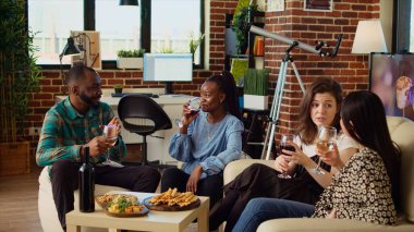 Çeşitli arkadaşların birlikte eğlendiği yakın plan çekimler şarap ve şampanya kadehlerini tokuşturup arkadaşlıkları için kadeh kaldırmalar. Çok ırklı bir grup insan apartman dairesinde parti veriyor, kutlama yapıyorlar.