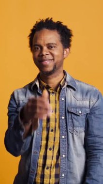 Dikey Video Şirin romantik evli çift hava öpücüğü gönderiyor ve birlikte poz veriyorlar, gülümsüyorlar ve birbirlerine minnettarlar. Afrikalı Amerikalı erkek ve kadın stüdyoda flört ediyorlar. Kamera B.