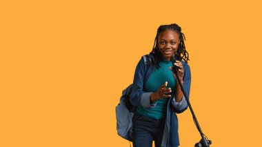 Afrika kökenli Amerikalı motivasyon konuşmacısının portresi mikrofonla konuşuyor, izleyicilere hitap ediyor, stüdyo arka planında izole edilmiş. Mikrofon kullanan etkileyici konuşmacı, ilham verici motivasyon, kamera B