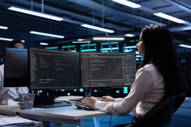 Donanım güncellemesinden sonra veri merkezindeki teknisyen bilgisayardaki ekipman performansını kontrol ediyor. IT uzmanı sunucular, depolama cihazları ve ağ donanımı gibi bileşenleri kontrol ediyor