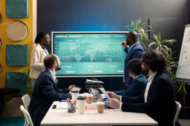 Kurumsal geliri artırmak için çözümlerini sunan mali danışman, küresel genişleme için bir strateji geliştirmek için pazar eğilimlerini değerlendiren ekip üyeleri. Personel finansman olanaklarını araştırıyor.