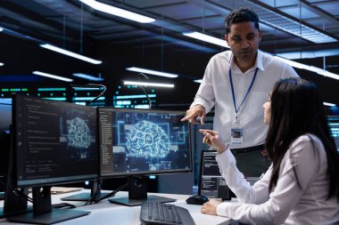 Veri merkezinde yapay zeka teknolojisiyle bilgisayar üzerinde çalışan takım çalışanları. İş arkadaşları beyin fırtınası yapıyor, sunucu merkezindeki görevleri çözüyor derin öğrenme için kullanılan veri depolama merkezlerinde